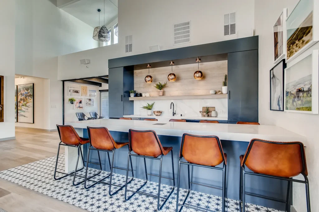 Clubhouse lounge with sofas, fire place, tv, and kitchen