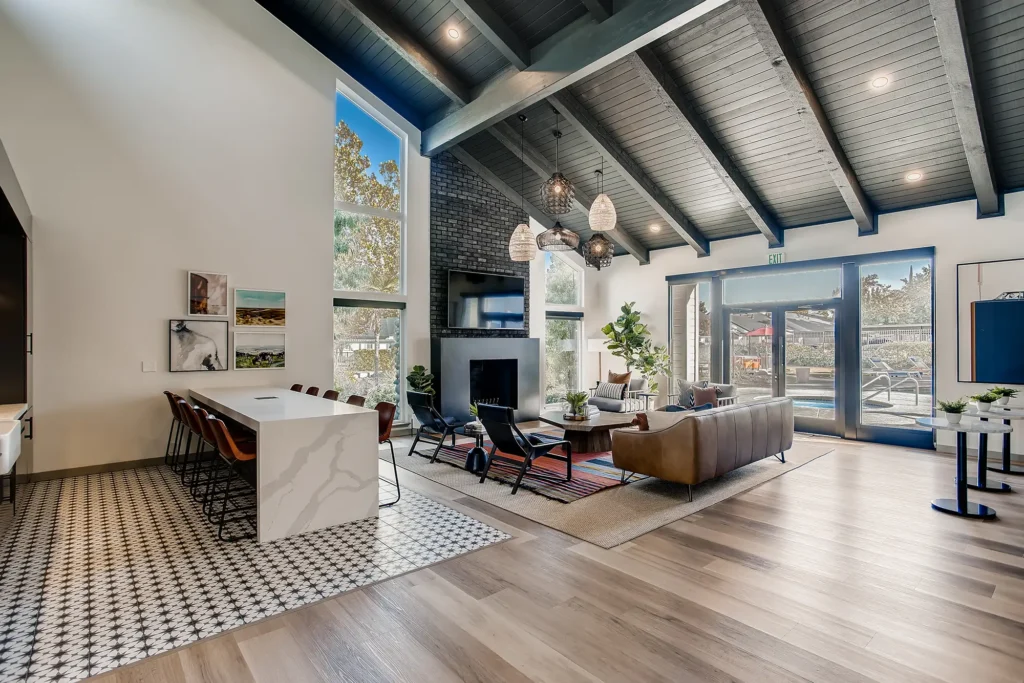 Clubhouse lounge with sofas, fire place, tv, and kitchen