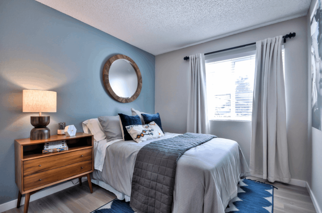 Bedroom with large window and blue accent wall