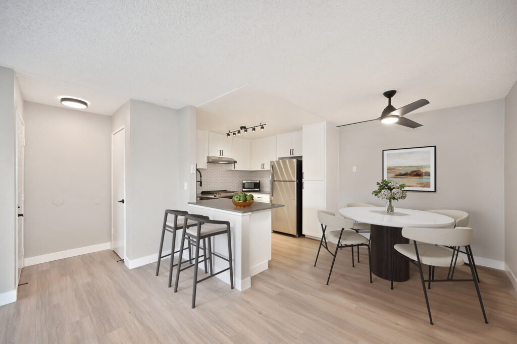 Renovated apartment dining area with view into kitchen and front entry.